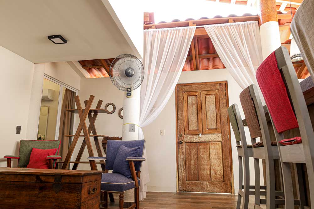 Una puerta de madera y un ventilador en la habitación, generando un ambiente cálido y práctico.