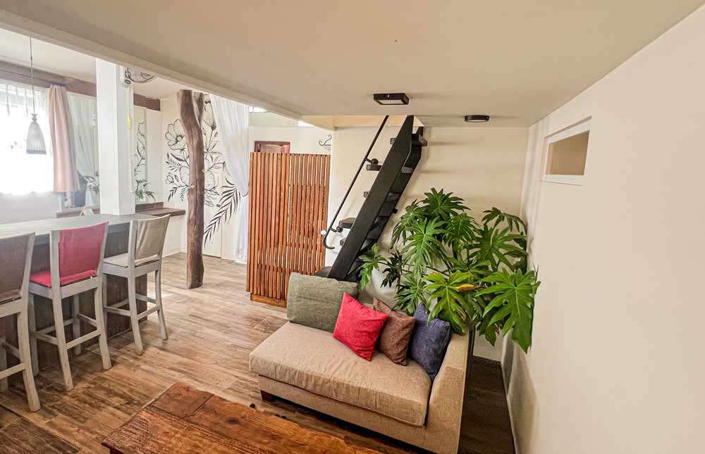 Sala de estar con una escalera elegante y un sofá cómodo, creando un ambiente acogedor y moderno.